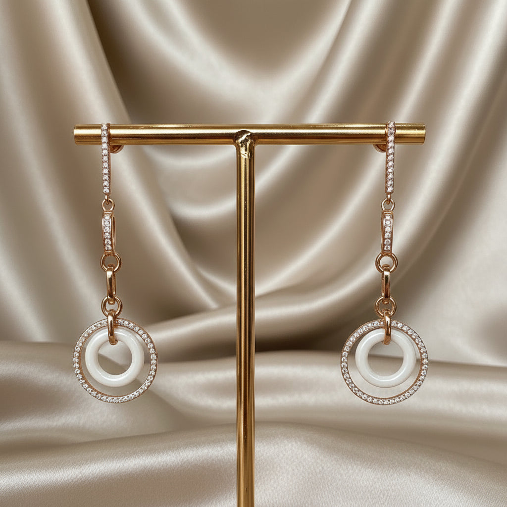 Pair of earrings on a gold stand against a satin background